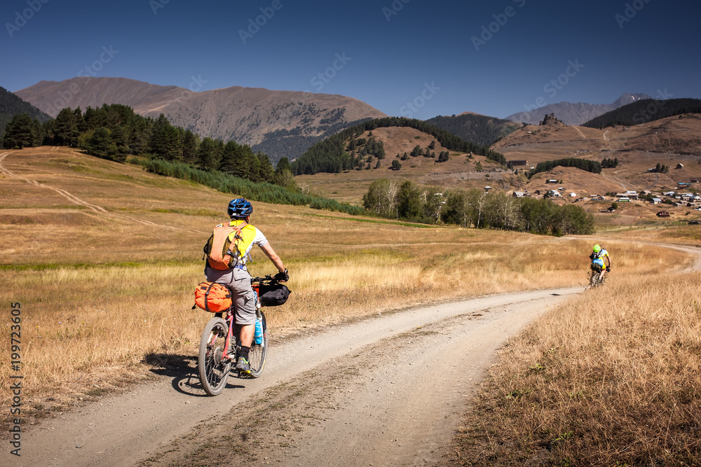 Mountain bikers are travelling in the highlands of Tusheti region, Georgia Mountain bikers are travelling in the highlands of Tusheti region, Georgia