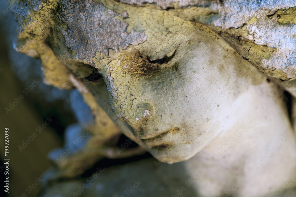 Close up of sad guardian angel. (fragment of an antique statue) Close up of sad guardian angel. (fragment of an antique statue)