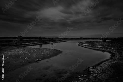 black and white photo of a river that leads out to the sea