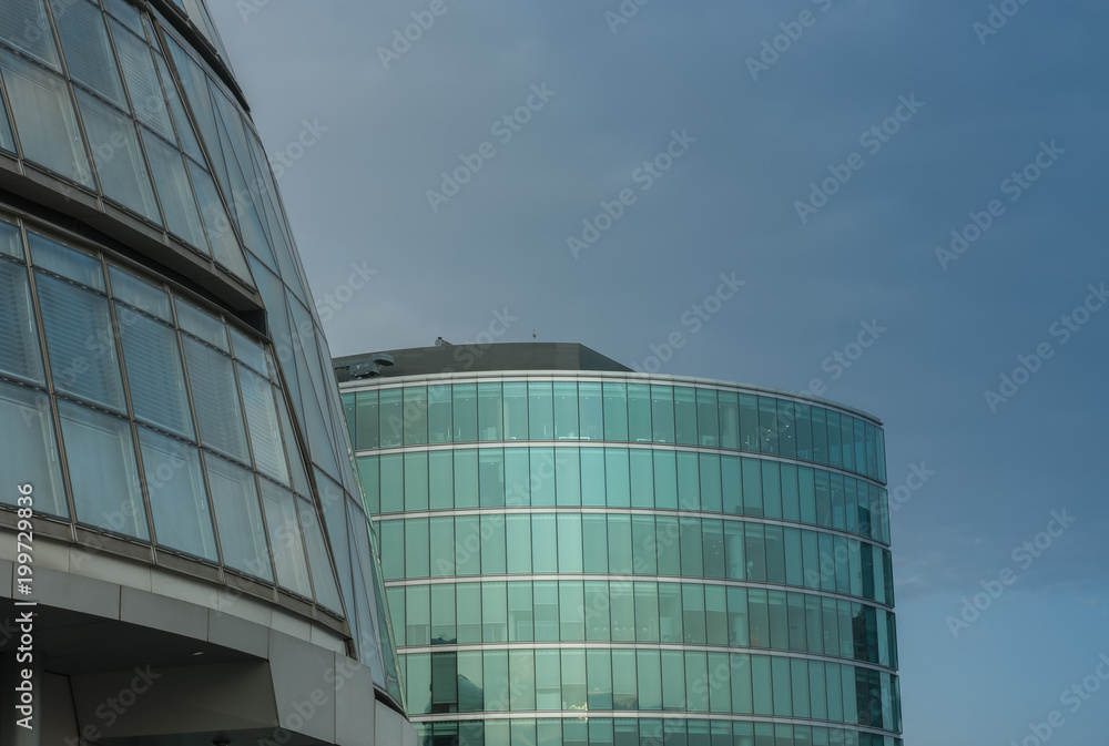 Roofs and glass facades of modern skyscrapers, blue sky on background.