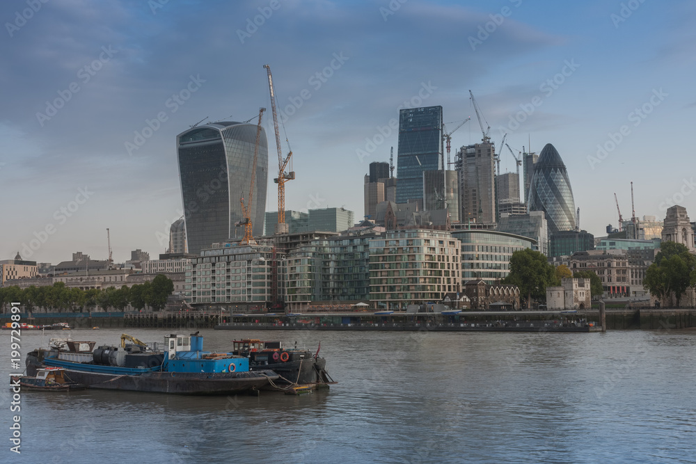Refuse barge on Thame, on background embankment and london skyscrapers in City of London