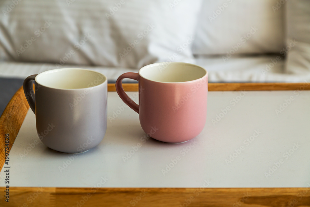 Close up grey and pink cups on breakfast tray in bedroom Close up grey and pink cups on breakfast tray in bedroom