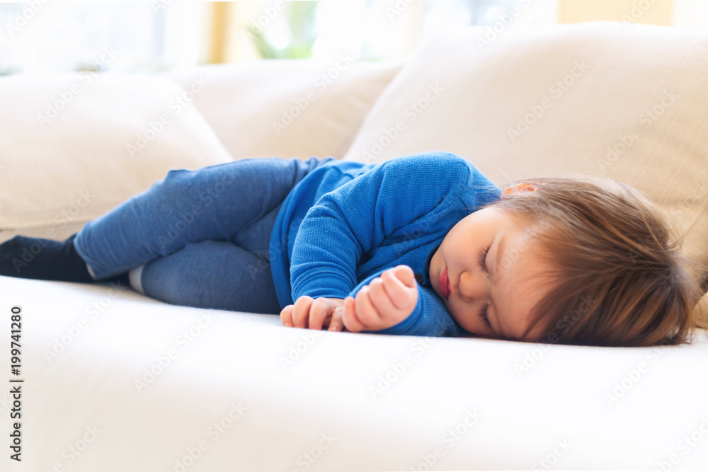 Sleepy toddler boy napping in the afternoon on a sofa Sleepy toddler boy napping in the afternoon on a sofa