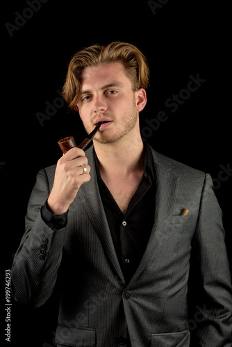 Male model in a classy dark suit isolated against a black background.