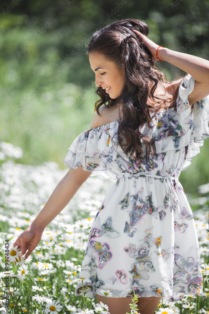Pretty young woman in the chamomile field. Beautiful girl with flowers Pretty young woman in the chamomile field. Beautiful girl with flowers