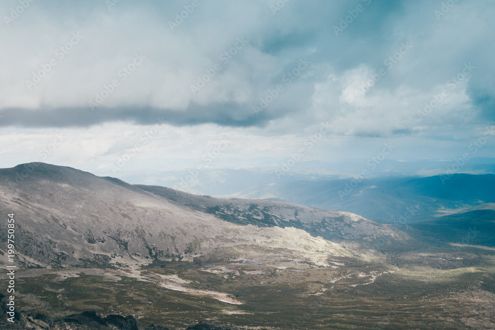 Beautiful view of the rocky ridge. Colorful mountains under the clouds. Beautiful view of the rocky ridge. Colorful mountains under the clouds.