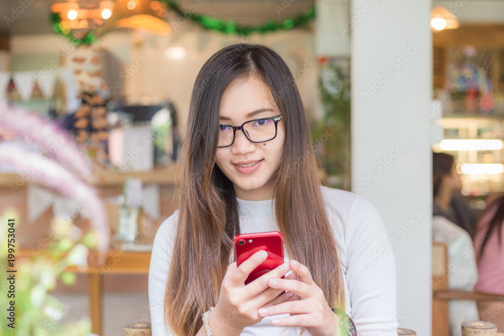 Glasses asian nerd women texting on smartphone Glasses asian nerd women texting on smartphone