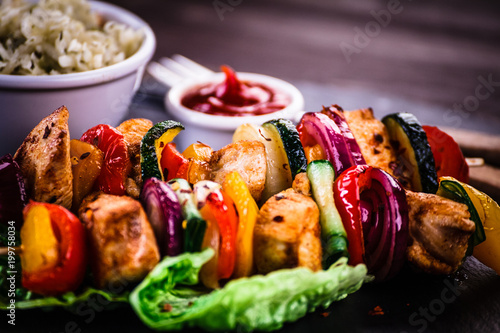 Kebabs - grilled meat with vegetables on wooden background 