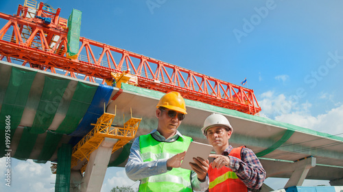 two Male Engineer using tablet computer at constructions site