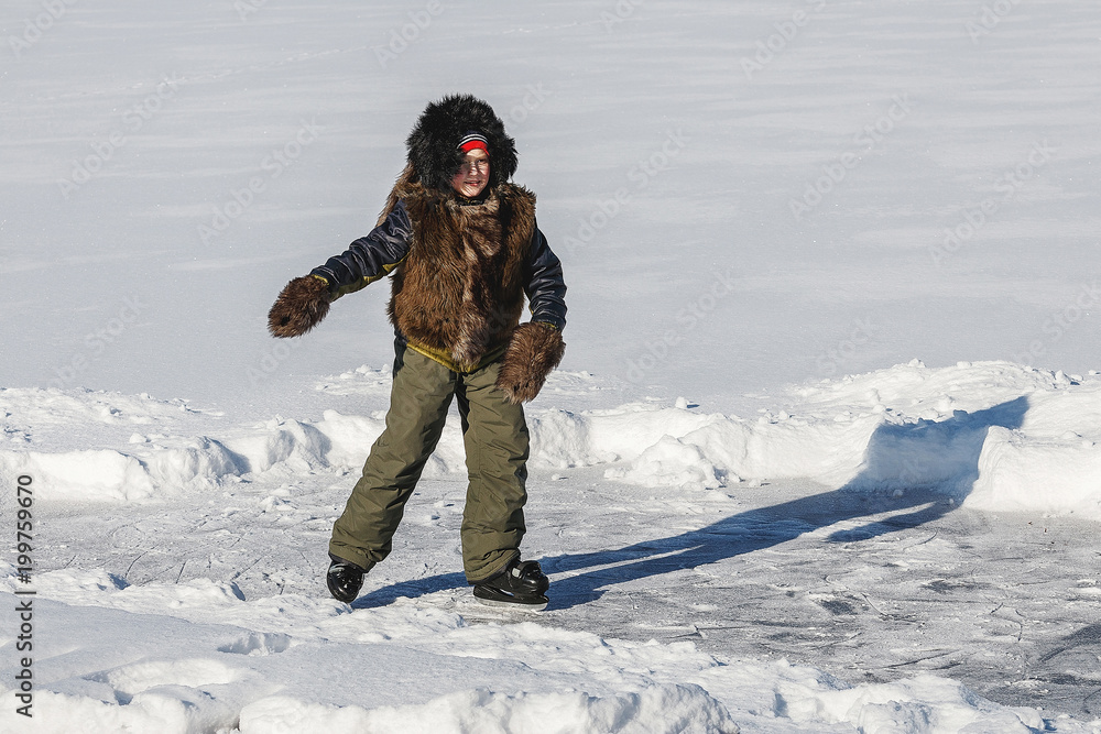 boy skates in cold white winter on frozen lake