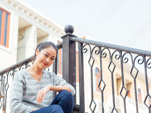 Tourist girl relax on the bridge with beautiful European buildng in the background. photo