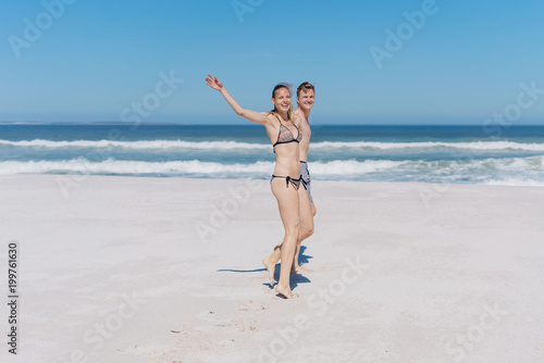 Carefree young woman waving at the camera