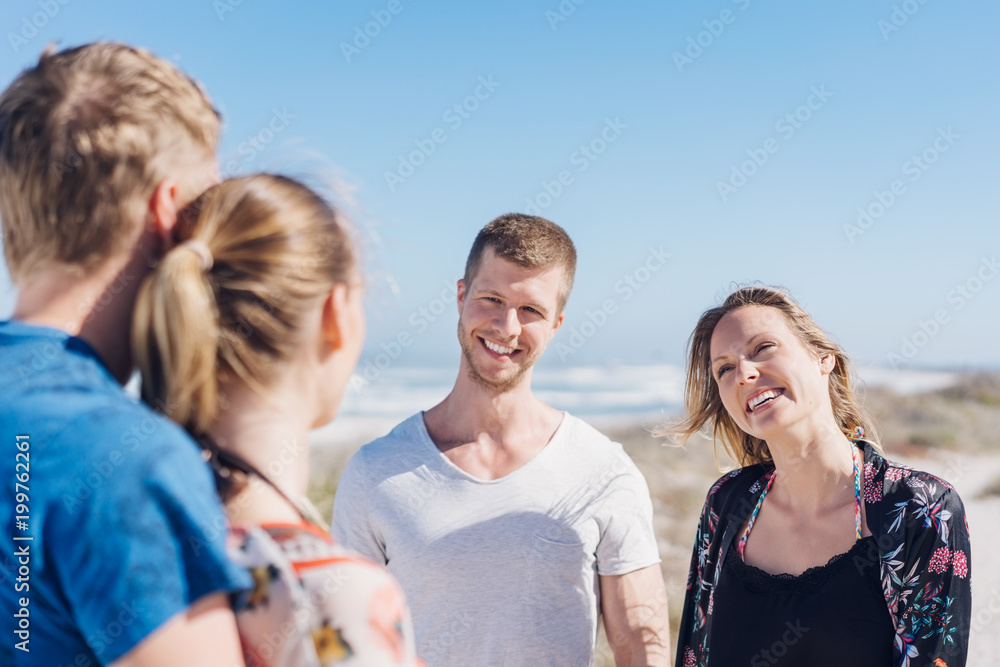 Two young couples chatting at the seaside Two young couples chatting at the seaside