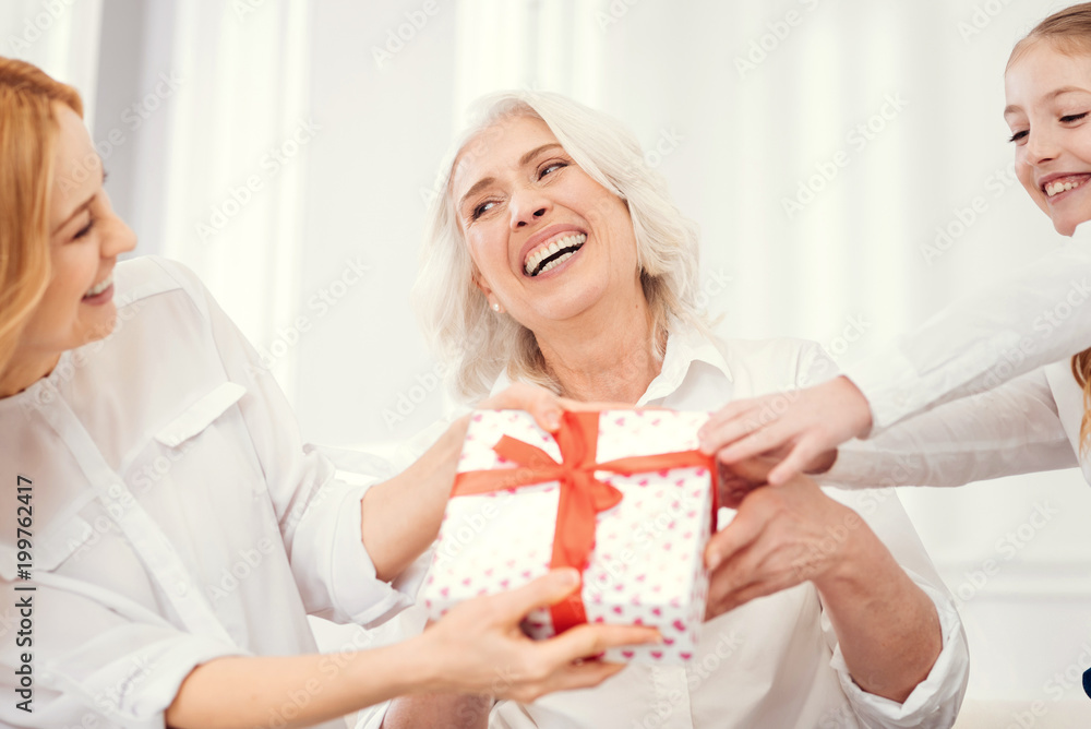 Never get bored. Excited women sitting on a sofa and playing tricks while sharing a family moment and spending time together at home. Never get bored. Excited women sitting on a sofa and playing tricks while sharing a family moment and spending time together at home.