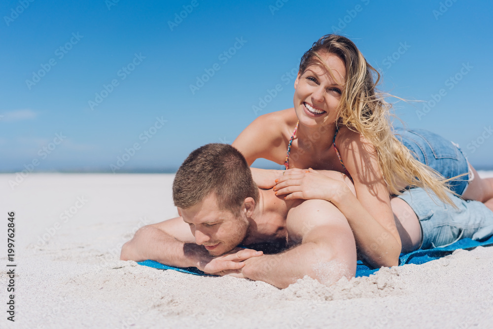 Happy young woman at the beach with her boyfriend