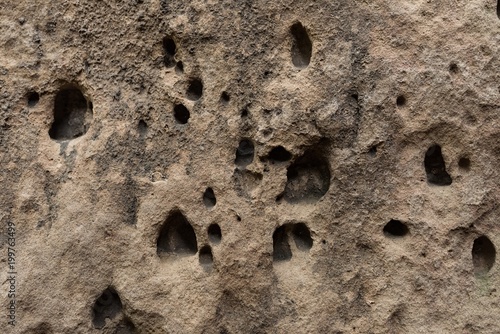 Surface of the sand rock with small and big holes made by erosion 