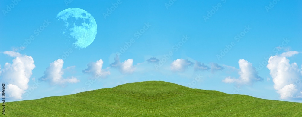 Green field and blue sky with clouds, panoramic view