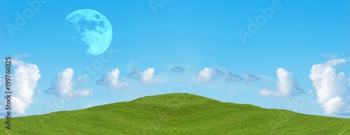 Green field and blue sky with clouds, panoramic view