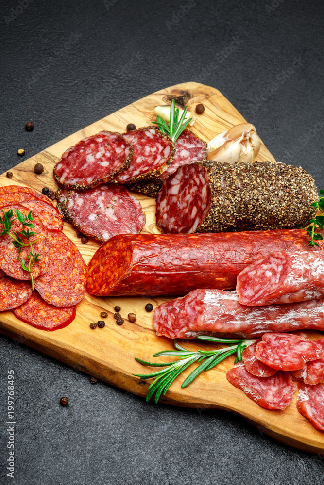 Dried organic salami sausage on wooden cutting board Dried organic salami sausage on wooden cutting board