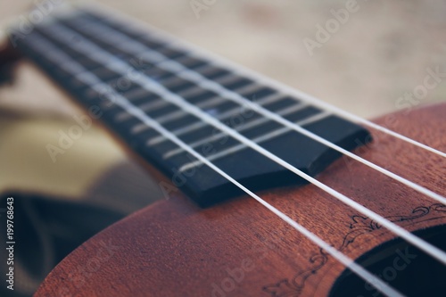 Ukulele guitar on a sand close up