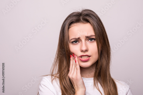 Photography woman suffering from toothache, tooth decay or sensitivity isolated on gray