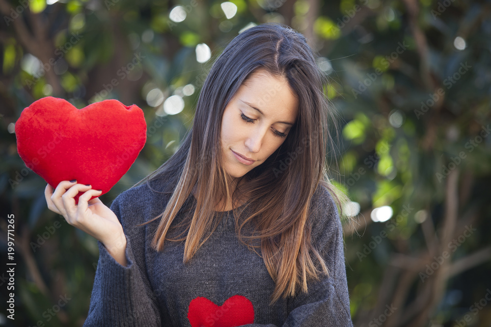 Broken heart love concept. Sad unhappy woman holding red heart Broken heart love concept. Sad unhappy woman holding red heart