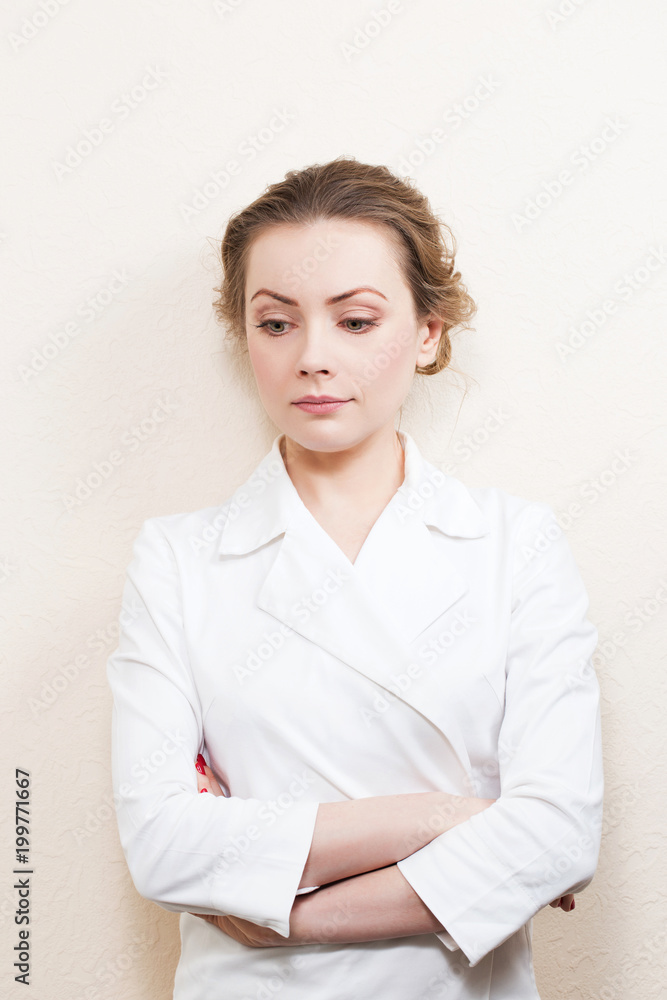 Girl cosmetician doctor in white lab coat against white wall. Girl cosmetician doctor in white lab coat against white wall.