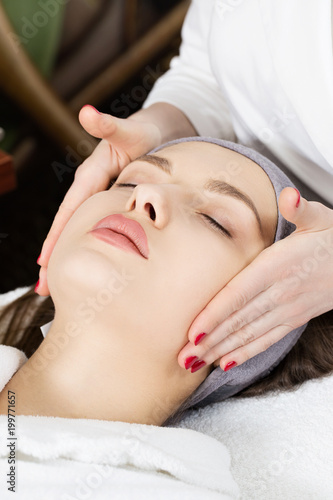 Facial massage for a beautiful girl in a spa salon
