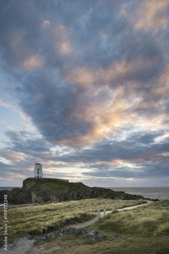 Landscape image of Twr Mawr Lighthouse on Ynys Llanddwyn Island in Angelsey during dramatic sunset