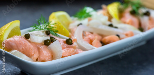 Salmon in a marinade of lemon juice with green pepper and onion - healthy food - closeup, banner