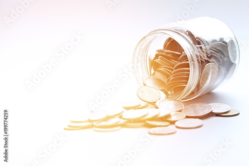 Wallpaper Mural Business, finance, saving money or investment concept : Coins scattered from glass jar on white background Torontodigital.ca