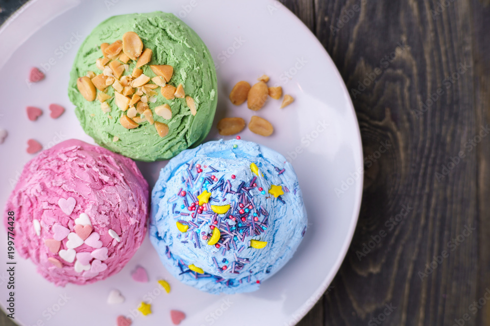 Set of strawberry, pistachio and blueberry flavored ice cream scoops with nuts and sugar sprinkles on white plate, top view. Delicious summer snacks Set of strawberry, pistachio and blueberry flavored ice cream scoops with nuts and sugar sprinkles on white plate, top view. Delicious summer snacks
