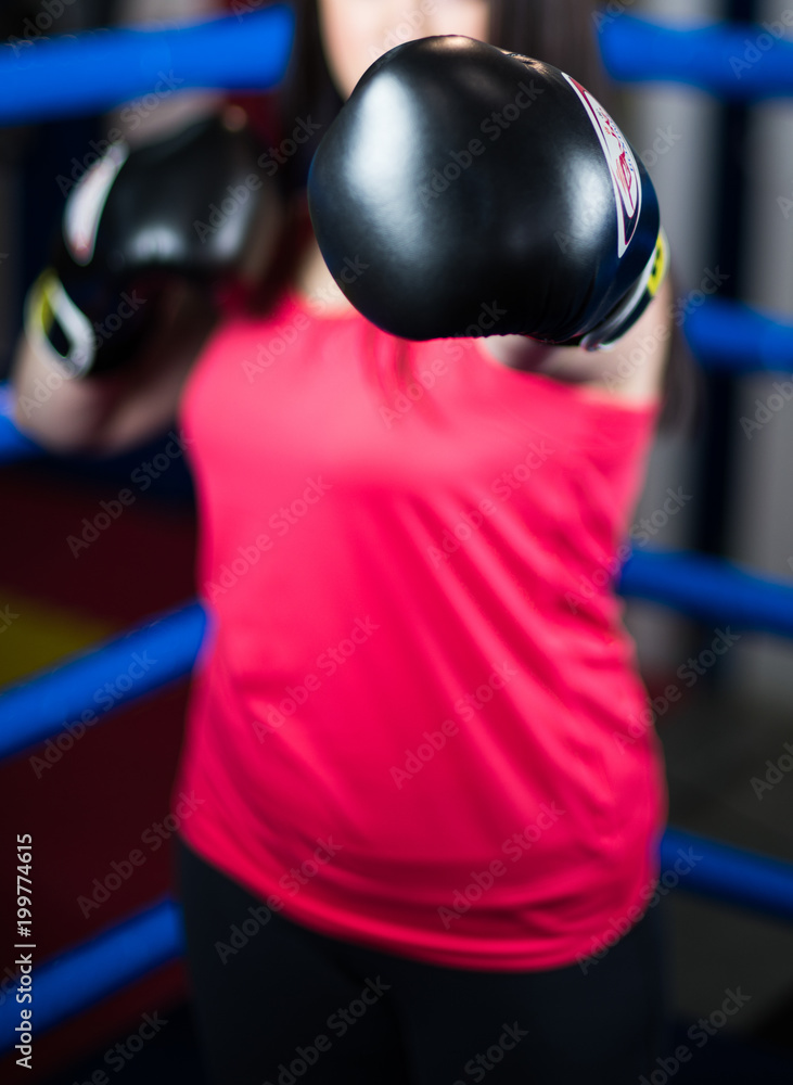 Blurred background. The girl-the boxer extended his hand Boxing gloves black. Boxing. . Blurred background. The girl-the boxer extended his hand Boxing gloves black. Boxing. .