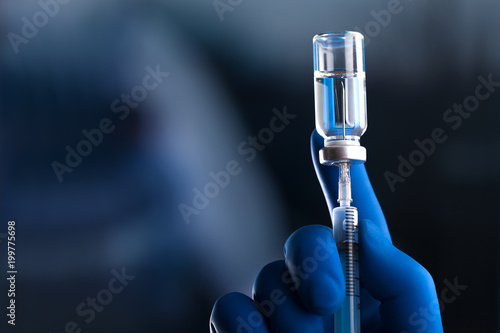 Doctor hand holds syringe and vaccine photo