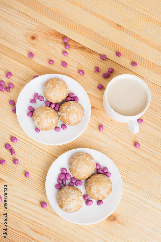 gingerbread on plates, coffee wiht milk and pink candy on a wooden background. breakfast or snack gingerbread on plates, coffee wiht milk and pink candy on a wooden background. breakfast or snack