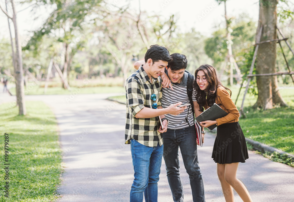Group of cheerful friends watching the smart phone outdoor Group of cheerful friends watching the smart phone outdoor