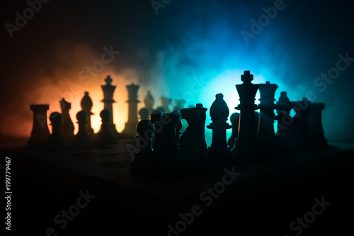 Chess board game concept of business ideas and competition and strategy ideas concep. Chess figures on a dark background with smoke and fog. Business leadership and confidence concept.