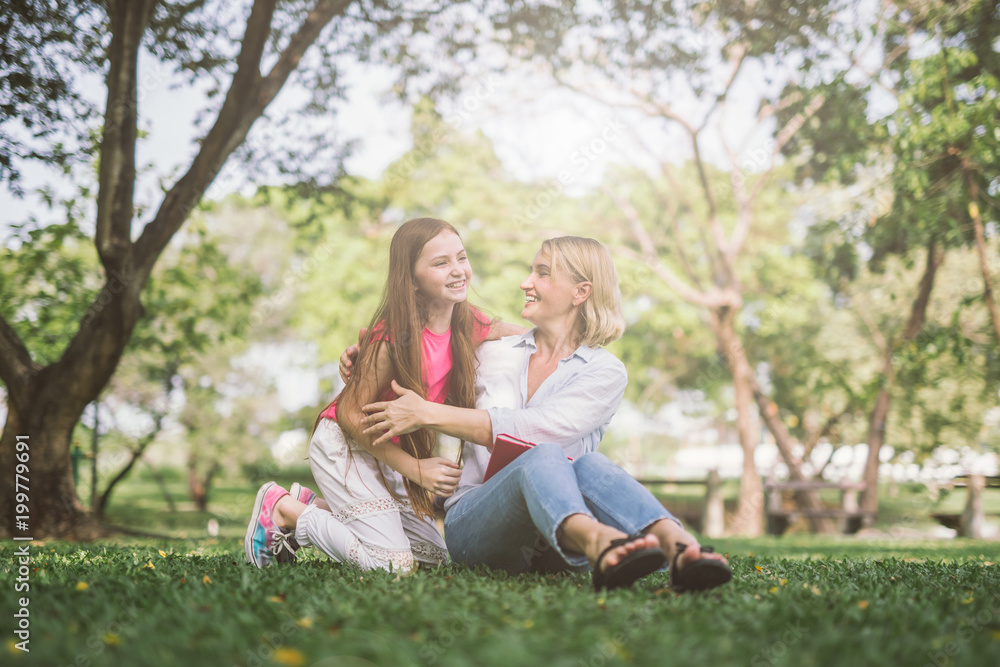 mom and daughter talking and hugging in park mom and daughter talking and hugging in park