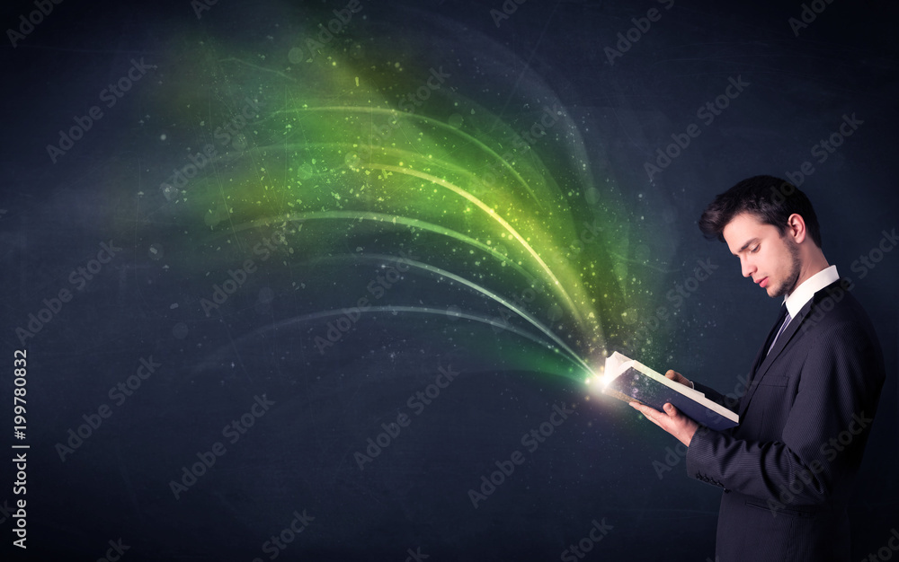 Casual young man holding book with green wave flying out of it Casual young man holding book with green wave flying out of it