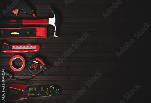 tools for home repair in red style on a black wooden background