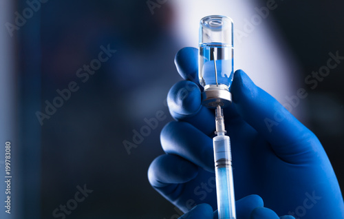 Medical hands holds syringe and vaccine photo