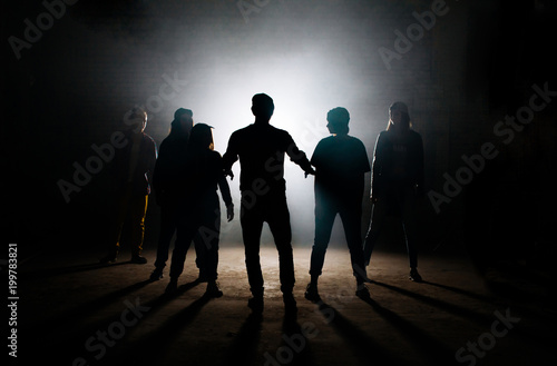 man teaching his friends hip hop on the dark studio. solve conflict. mental aproach for performance. calm down teens.learning dance photo