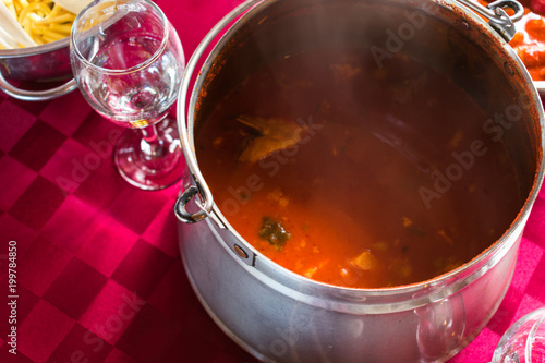 Close up and top view of a spicy fish stew on a red table cloth, a popular dish in eastern Croatia