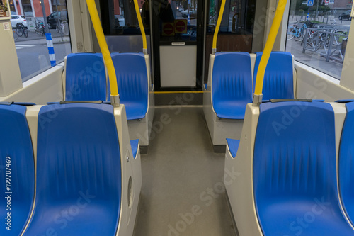 Tram inside, city transportation interior with blue seats yellow handles © mp_visuals