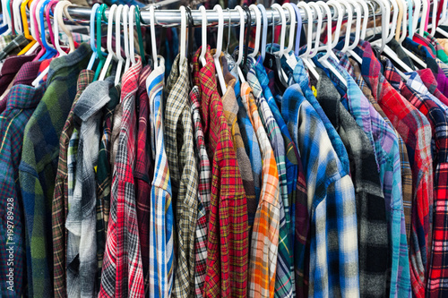 close-up on flannel shirts on clothes railings in a vintage thrift store 