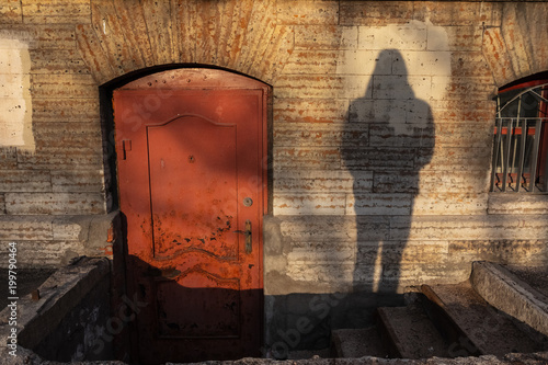 Shadow of human try to open the old red door photo