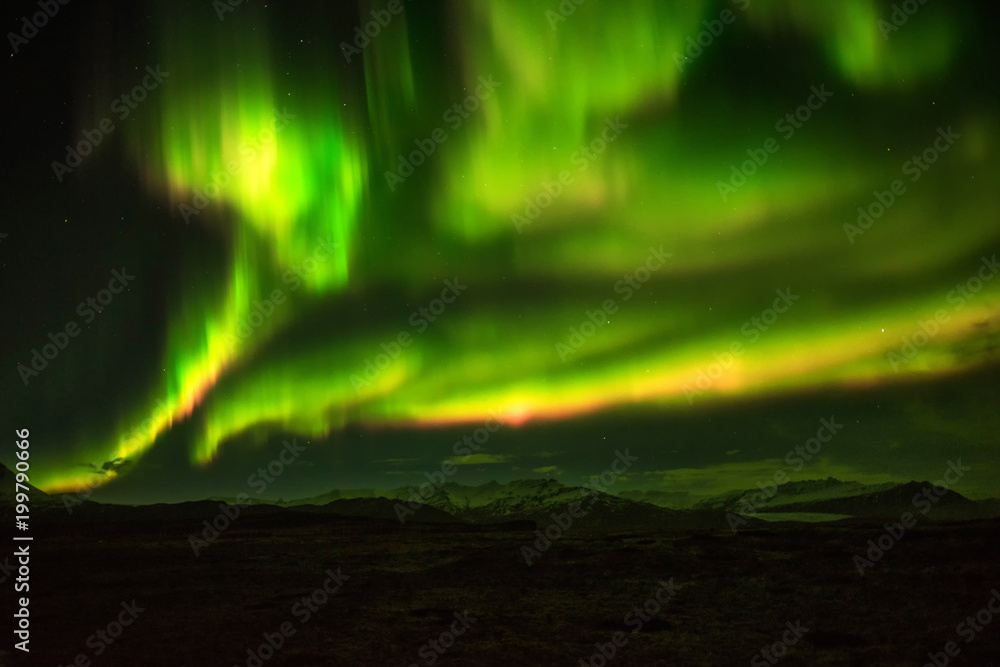 A wonderful night with Kp 5 . Northern lights mountain in Iceland. Background blurred.