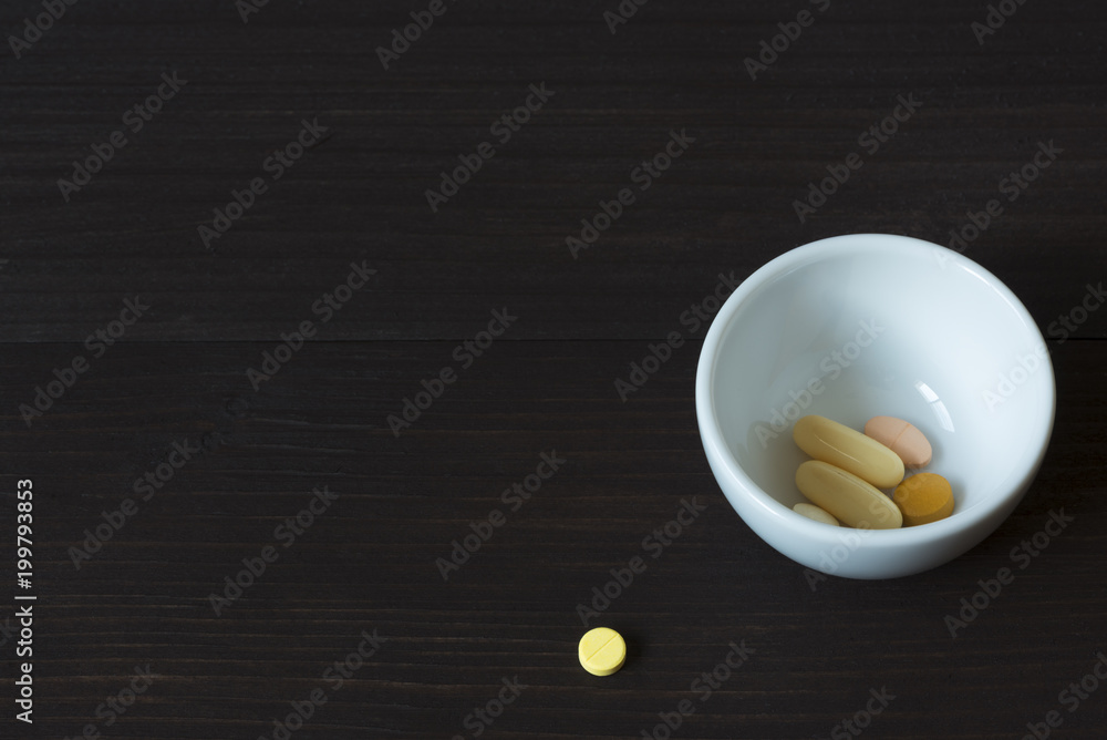 A tablet of medication and drugs in a ceramic cup