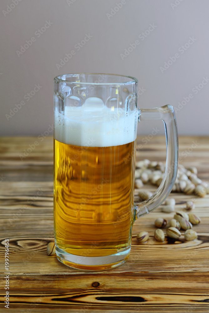 glass of beer with pistachios on a wooden background glass of beer with pistachios on a wooden background