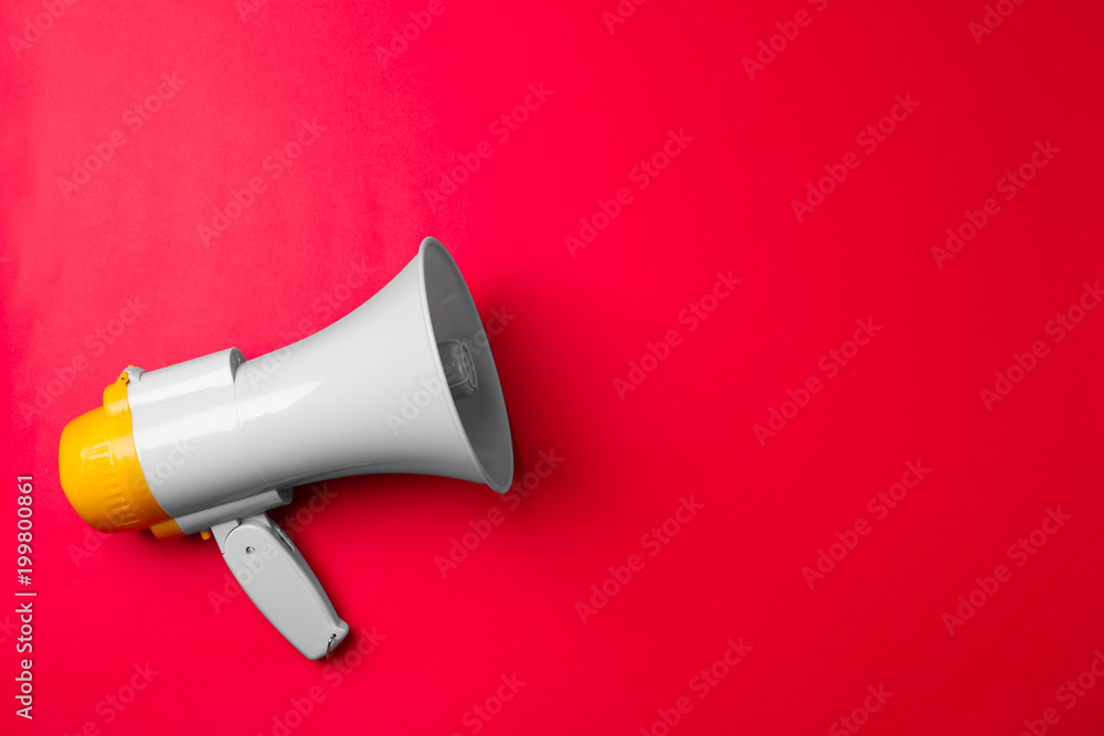 Electronic megaphone on color background